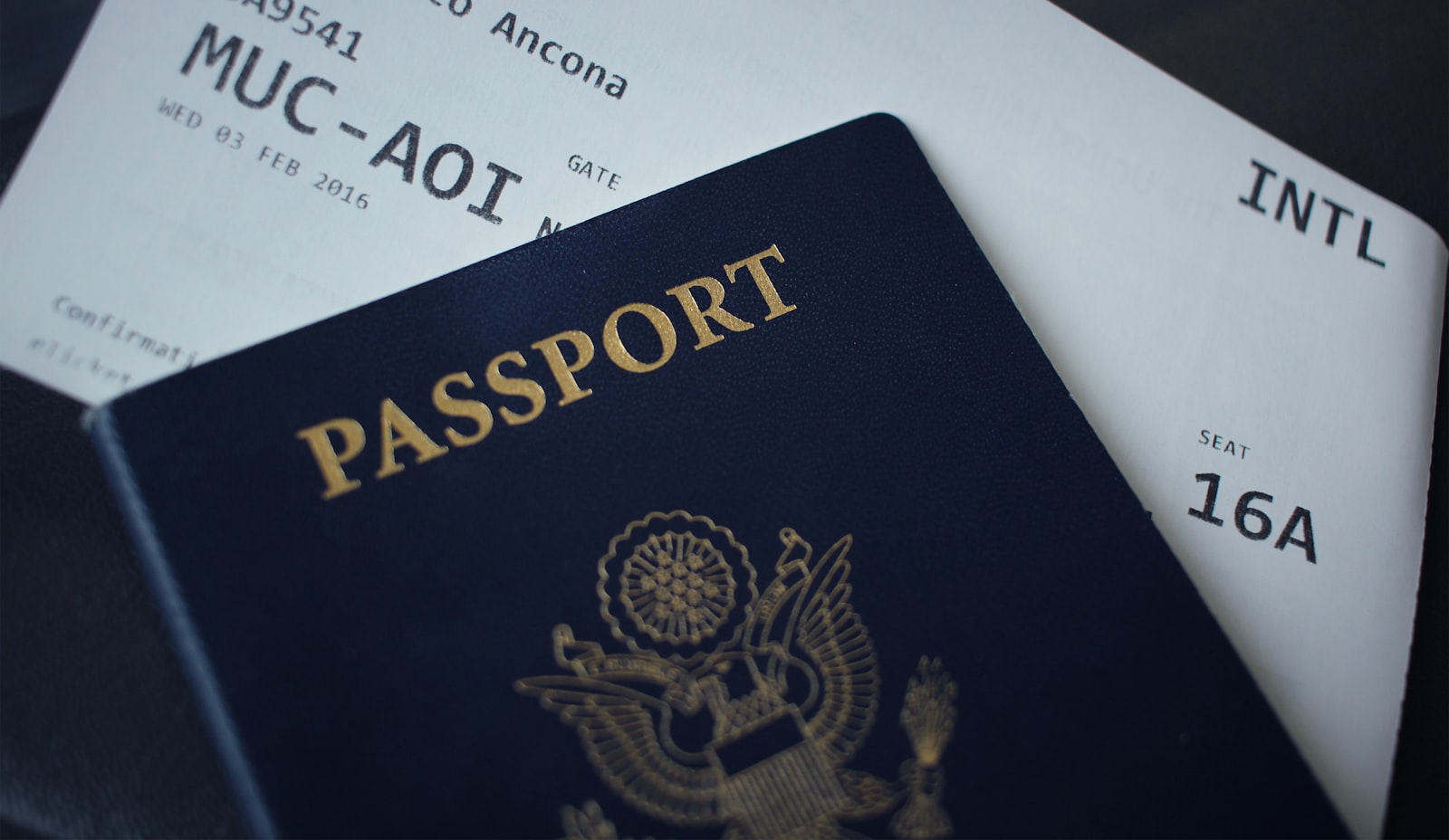 A passport resting on top of travel documents